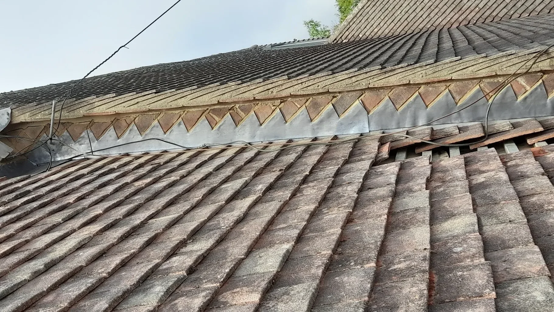 Lead step flashing where a tiled roof meets a brick wall, fitted by LDR Roofing